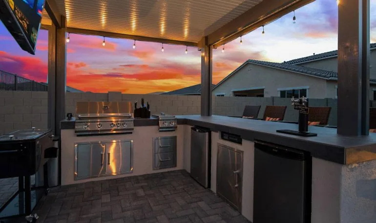 Custom outdoor kitchen with grill island under string lights